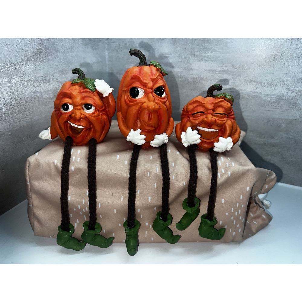 VINTAGE SET OF 3 PUMPKIN SITTER FEATURE DANGLING LEGS AND EXPRESSIVE FACES.